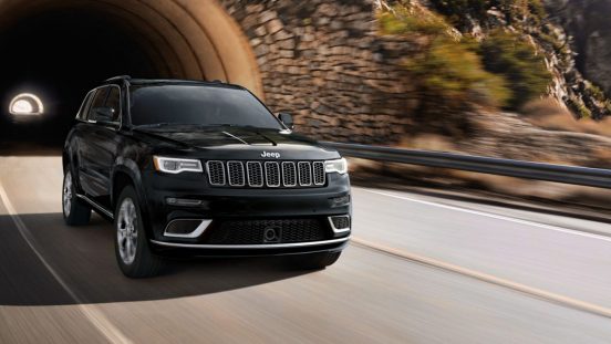 Image of a black 2019 Jeep Grand Cherokee driving through a highway tunnel.