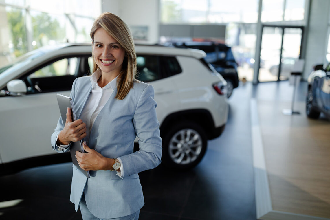 Sales rep greeting customer at auto dealership